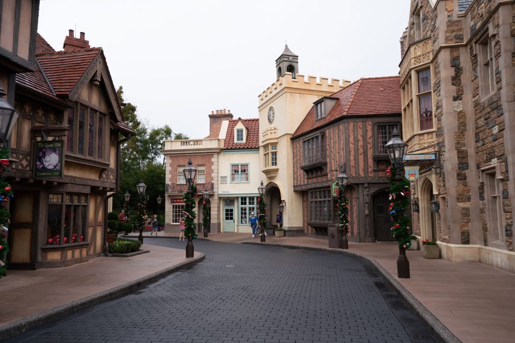 Tudor style buildings and a cobblestone street decorated for the holidays in the UK Pavilion at Epcot