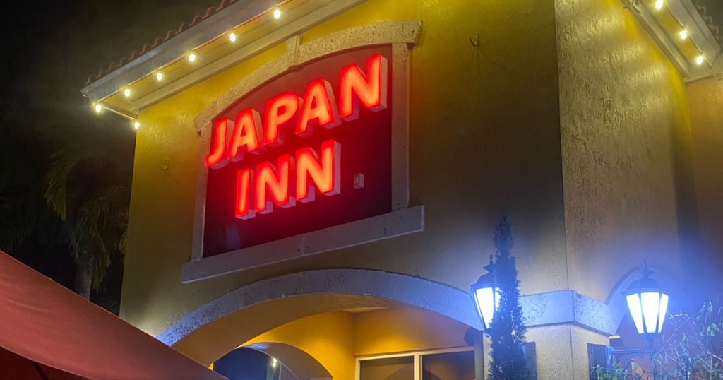 Illuminated red neon sign for the Japan Inn Hibachi and Sushi restaurant at night