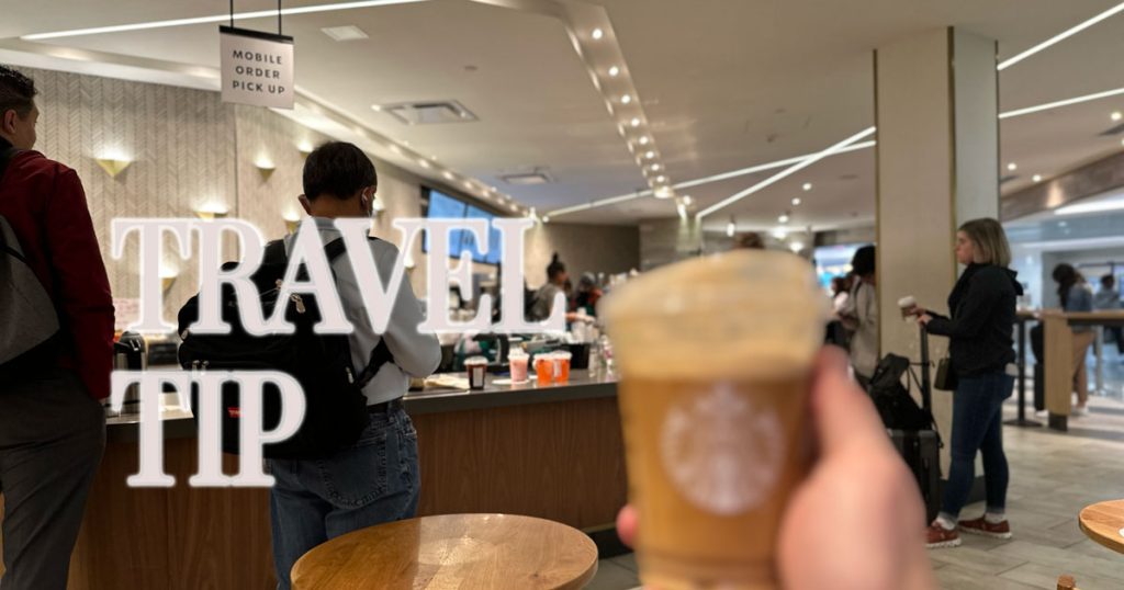 Use Starbucks Mobile Ordering When Traveling 1 Iced coffee held up near an airport Starbucks counter with a mobile order pickup sign