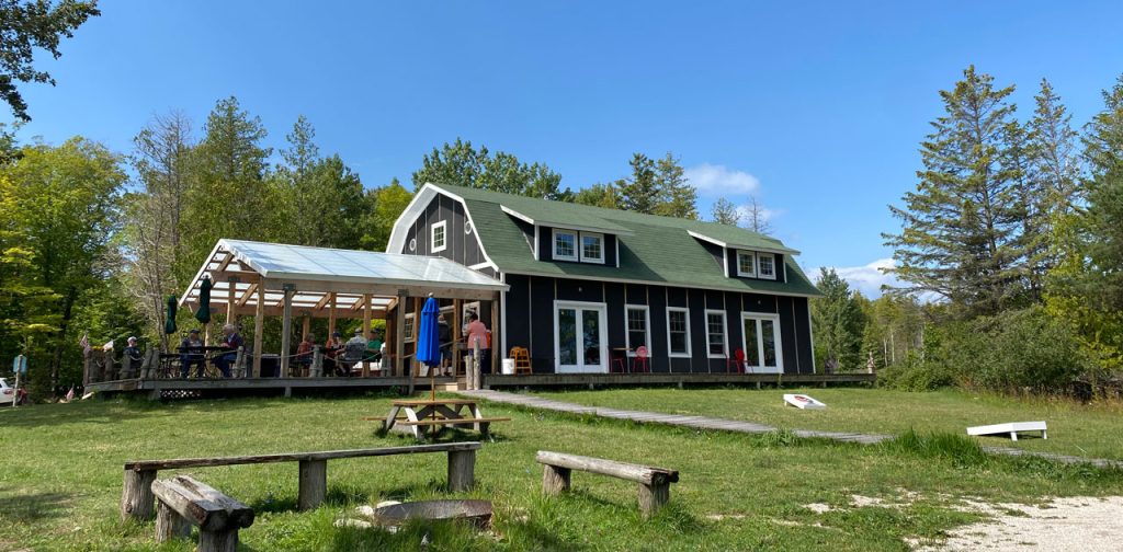 Jackson Harbor Soup Serves Best Food on Washington Island 1 Jackson Harbor Soup restaurant building with a covered porch and lawn games on Washington Island