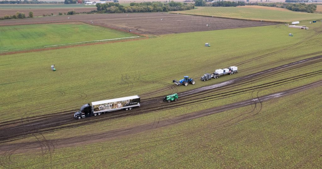 Luke Bryan Farm Tour Cancelled in Eyota, MN Due to Weather 1 Aerial view of a semi truck and tractor stuck in a muddy farm field for the Luke Bryan Farm Tour