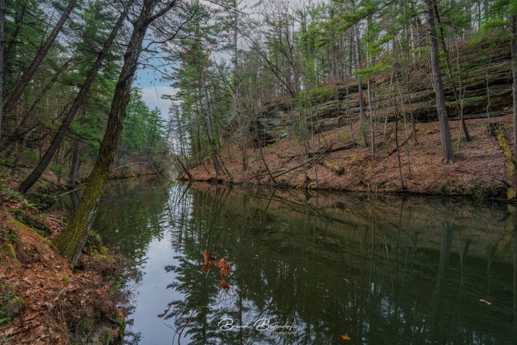 Hiking Pulpit Rock: Discover Mirror Lake State Park's History, Trails, and Scenic Views 1 Layered sandstone bluff reflected in still water along the trail to Pulpit Rock, Mirror Lake State Park